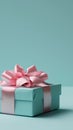Stylish mint gift box with a soft pink ribbon on a pastel blue background, modern appeal Royalty Free Stock Photo