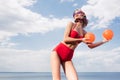 stylish model in vintage red bikini sunglasses and silk scarf posing with balls