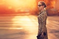 Stylish model woman posing in evening wearing dress with leopard print on city street Royalty Free Stock Photo