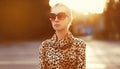 Stylish model woman posing in evening wearing dress with leopard print on city street Royalty Free Stock Photo