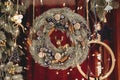 Stylish modern christmas wreath, branches, ornaments in lights in evening. Atmospheric magic time. Modern Christmas festive decor