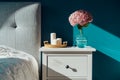 Stylish modern cosy bedroom in dark colors. Cozy interior with turquoise walls, home decor. Bed with grey fabric Royalty Free Stock Photo