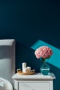 Stylish modern cosy bedroom in dark colors. Cozy interior with turquoise walls, home decor. Bed with grey fabric Royalty Free Stock Photo