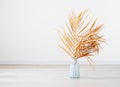 Stylish modern dry palm leaves in glass vase on a wooden light floor in room in Scandinavian style. Art deco, boho gift for Royalty Free Stock Photo