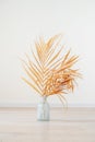 Stylish modern dry palm leaves in glass vase on a wooden light floor in room in Scandinavian style. Art deco, boho gift for Royalty Free Stock Photo