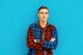 Stylish modern handsome young man in a multi-colored fashionable plaid shirt with hairstyle in a t-shirt posing outdoors in the Royalty Free Stock Photo