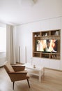 Stylish modern living room interior design with TV, armchair, coffee table and a window with curtains.