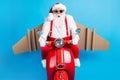 Stylish modern surprised white grey hair bearded santa claus with craft plane drive x-mas christmas red scooter fast Royalty Free Stock Photo