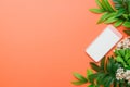 Stylish modern tech device on a warm orange background surrounded by greenery for contemporary advertisements Royalty Free Stock Photo