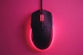 Stylish modern wired optical mouse displayed on a vibrant pink background from above Royalty Free Stock Photo