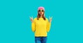 Stylish modern young woman model 20s blowing her lips sending sweet air kiss wearing colorful clothes, yellow knitted sweater and Royalty Free Stock Photo