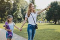 Stylish mother wearing cross shoulder bag having a walk with daughter Royalty Free Stock Photo