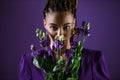 Stylish mulatto girl posing with purple eustoma flowers, Royalty Free Stock Photo