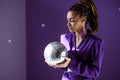 stylish mulatto model posing in purple jacket with disco ball, ultra