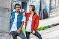 stylish multicultural couple with headphones standing at city