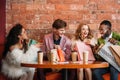 stylish multiethnic young people looking into shopping bags while drinking coffee