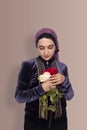 Stylish Muslim woman in traditional Islamic clothing holding flower bouquet. Portrait of a beautiful middle-eastern girl with the Royalty Free Stock Photo