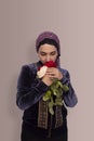 Stylish Muslim woman in traditional Islamic clothing holding flower bouquet. Portrait of a beautiful middle-eastern girl with the Royalty Free Stock Photo