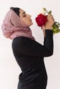 Stylish Muslim woman in traditional Islamic clothing holding flower bouquet. Portrait of beautiful middle-eastern girl in Hijab. Royalty Free Stock Photo