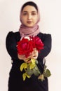 Stylish Muslim woman in traditional Islamic clothing holding flower bouquet. Portrait of beautiful middle-eastern girl in Hijab. Royalty Free Stock Photo