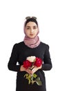 Stylish Muslim woman in traditional Islamic clothing holding flower bouquet. Portrait of beautiful middle-eastern girl in Hijab. Royalty Free Stock Photo