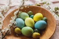 Stylish natural dyed easter eggs on wooden plate with spring flowers on rustic table. Happy Easter! Rustic Easter still life Royalty Free Stock Photo