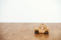 Stylish natural wooden car toy on table on white wall background. Space for text. Eco friendly plastic free toy for toddler.