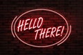 Stylish neon sign with phrase Hello there on brick wall Royalty Free Stock Photo