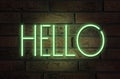 Stylish neon sign with word Hello on brick wall