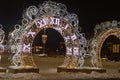 Christmas festive city street decorations - luminous clock and arch with garlands. New Year\'s illumination on the centra Royalty Free Stock Photo