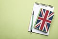 Stylish notebooks and pencil on green background, top view with space for text. Learning English Royalty Free Stock Photo