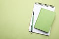 Stylish notebooks and pencil on light green background, top view. Space for text Royalty Free Stock Photo