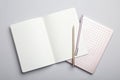 Stylish notebooks and pens on grey background