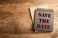 Stylish notebooks with phrase SAVE THE DATE on wooden table. Space for text