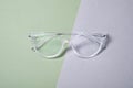 Stylish pair of glasses on color background, top view