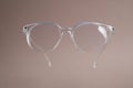 Stylish pair of glasses on pale brown background