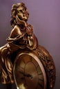 Stylish pair of golden wedding ring on metal gold woman figurine with clock, time concept