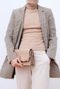 Stylish paris Lady. Details of everyday look. Casual beige checkered jacket and accessories bag and chain.Trendy Minimalistic