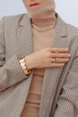 Stylish paris Lady. Details of everyday look. Casual beige checkered jacket and accessories rings and chain. Trendy Minimalistic