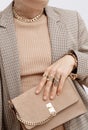 Stylish paris Lady. Details of everyday look. Casual beige checkered jacket and accessories velvet bag, rings and chain. Trendy