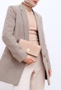 Stylish paris model. Details of everyday look. Casual beige checkered jacket and accessories bag and chain.Trendy Minimalistic