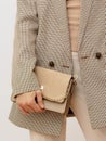 Stylish paris model. Details of everyday look. Casual beige checkered jacket and accessories bag. Trendy Minimalistic style.