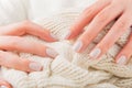 Pastel beige Nails holding knitted wool material Royalty Free Stock Photo