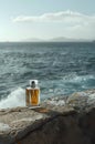 Perfume Bottle on Ocean Ledge in Bright Sunlight Royalty Free Stock Photo