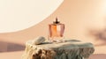 A stylish perfume bottle sits on a textured stone surface. The bottle is clear with a pink liquid inside, set against a Royalty Free Stock Photo