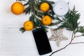 Stylish phone with empty screen and christmas oranges and golden Royalty Free Stock Photo