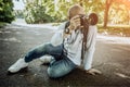 Stylish photographer with camera sidin on earth