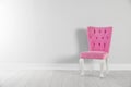 Stylish pink chair near white wall. Space for Royalty Free Stock Photo