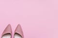 Stylish pink suede ladies shoes on pink paper background