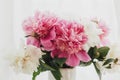 Stylish pink and white peonies in vase. Hello spring. Lovely peony bouquet in sunny light on rustic wooden window sill. Happy Royalty Free Stock Photo